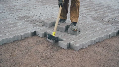 Builder makes a walkway with stone bricks or concrete pavers.  Vídeo Stock 148820736