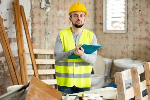 Builder making notes on indoor construction site Stock Photos