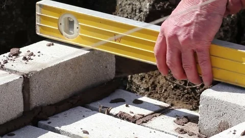 Builder making sure bricks are plumb with a spirit level Stock-Footage 72237674