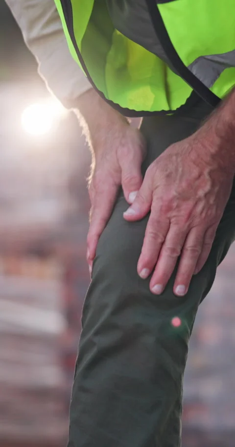 Builder, man and knee pain on construction site with injury, medical problem and Vídeos de archivo 340958050