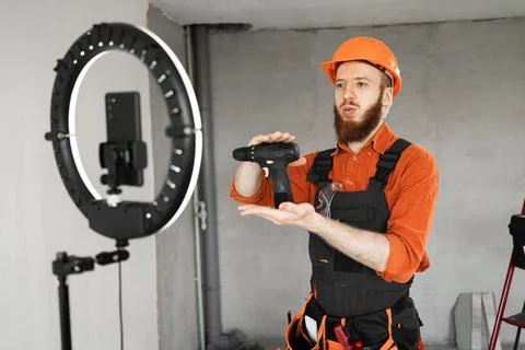 Builder man recording video tutorial with electric screwdriver, work in ren.. Stock Photos