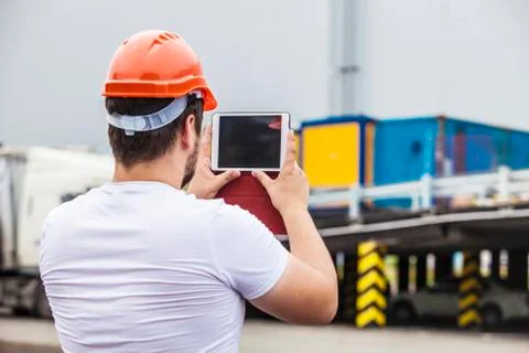 Builder man working with a tablet in a protective helmet Stock Photos
