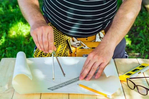 Builder master measures the distance in the drawing using a compass Stock Photos