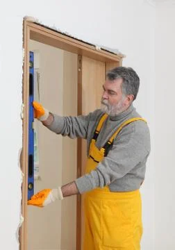 Builder measure verticality of door with level tool Photos