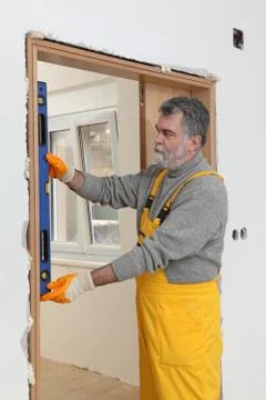 Builder measure verticality of door with level tool Stock-Fotos