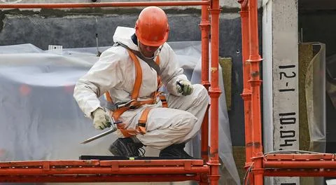 The builder measures the area wearing helmets, goggles and protective equip.. Stock Photos