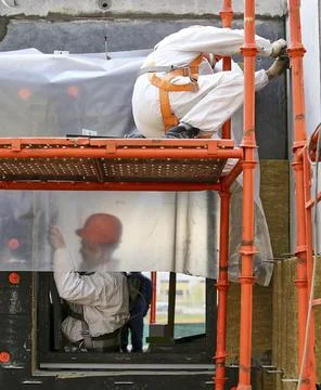 The builder measures the area wearing helmets, goggles and protective equip.. Stock Photos