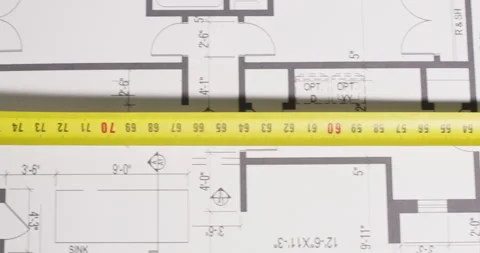Builder measures distance with retractable tape on plan Stock Footage 277562702