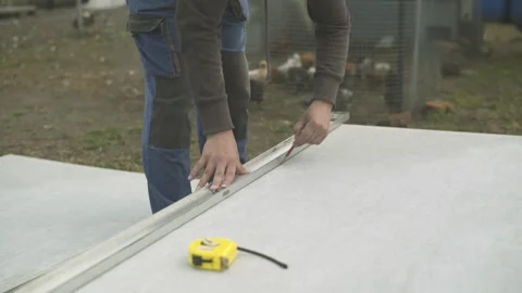 Builder measuring and marking a sheet of slate before cutting. Stock Footage 247523534
