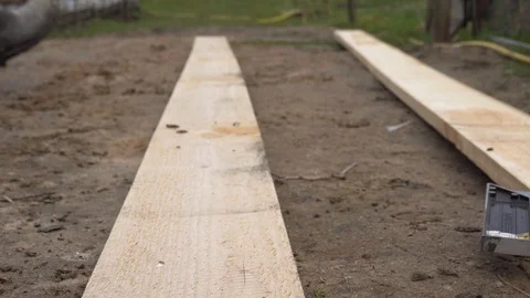 Builder is measuring a plank with measuring tape. Construction workflow. Video stock 129778717