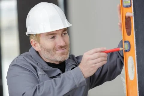 A builder measuring wall vertically Stock Photos