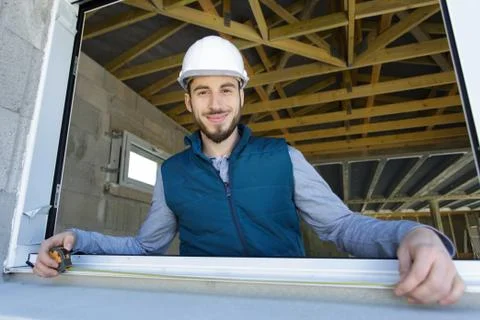 Builder measuring a window using a tape measure Stock Photos