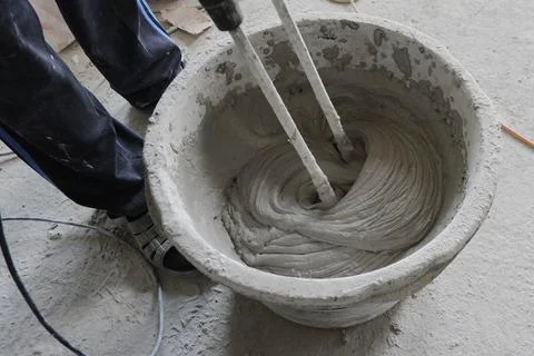 The builder mixes the construction mixture in a container for guiding the sol Stock Photos