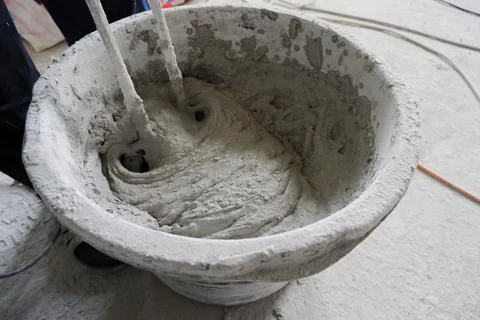 The builder mixes the construction mixture in a container for guiding the sol Stock Photos