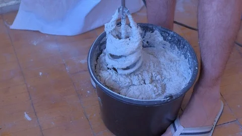 Builder mixing cement plaster in bucket using an electric mixer, closeup view. Vídeo Stock 123354022