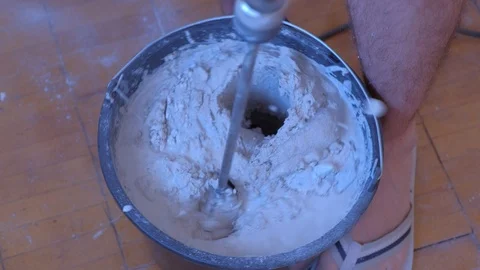 Builder mixing cement plaster in bucket using an electric mixer, closeup view. Video stock 123780422