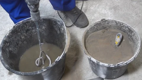 The builder is mixing concrete with plaster, apartment repair Stock Footage 115419242
