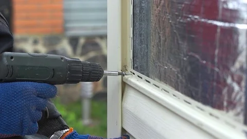 The builder mounts the facade of the house Stock Footage 75429786