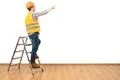 The builder near ladder gesturing on the white wall background Photo