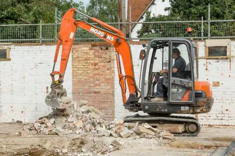 Builder operating a digger on UK building site Foto stock
