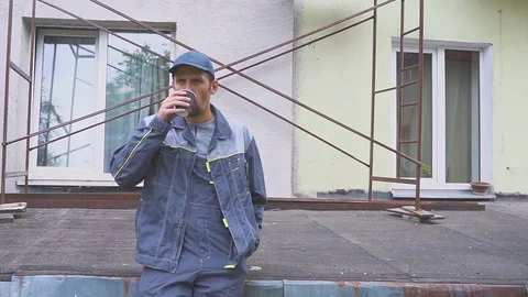 Builder or construction worker enjoying a cup of coffee near the construction Видео 90692912