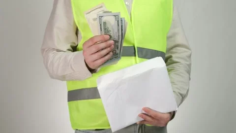 A builder or engineer with an envelope from which he takes out money. Payment Stock-Footage 314258346
