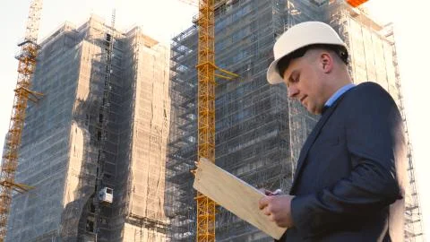 Builder or engineer, stands with his back looking at the buildings Stock Photos
