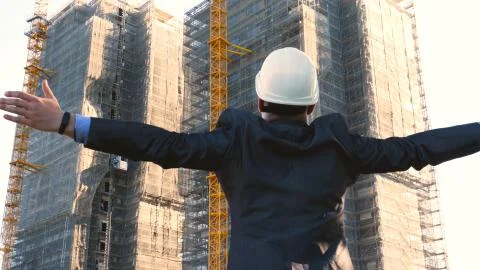 Builder or engineer, stands with his back looking at the buildings Stock Photos