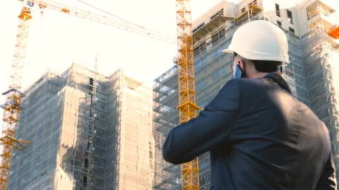 Builder or engineer, stands with his back looking at the buildings Stock Photos