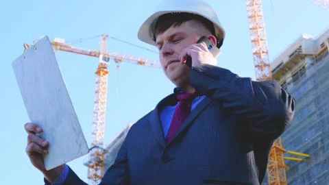 Builder or engineer, stands with his back looking at the buildings Stock Photos