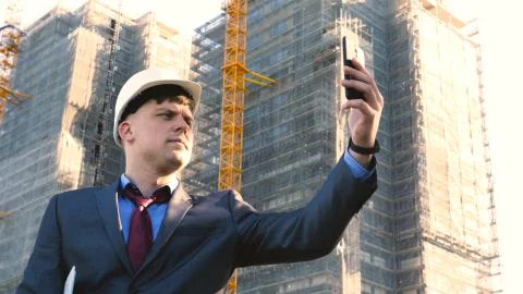 Builder or engineer, stands with his back looking at the buildings Stock Photos