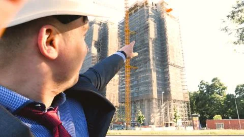 Builder or engineer, stands with his back looking at the buildings Stock Photos
