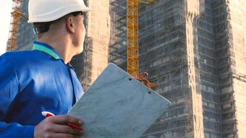 Builder or engineer, stands with his back looking at the buildings Stock-Fotos