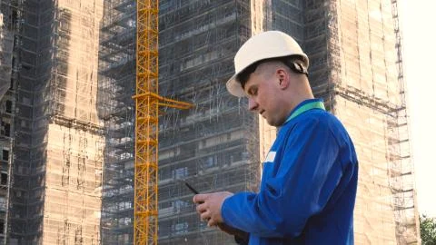 Builder or engineer, stands with his back looking at the buildings Stock Photos
