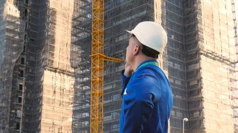 Builder or engineer, stands with his back looking at the buildings Stock Photos