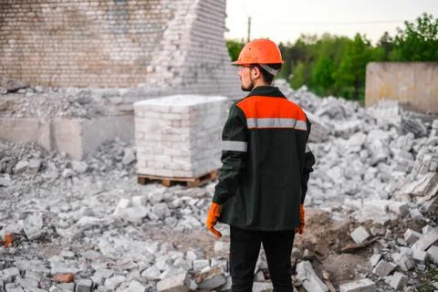 Builder packs bricks into pallets at construction site Stock Photos