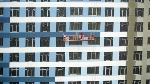 Builder paints the facade of a building at a construction site Stock Footage 105536650