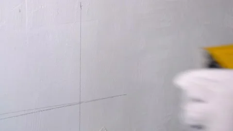 Builder with a pencil and a square mark the place for socket. Stock Footage 135143345