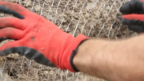 A builder places a construction grid for cement mortar on the wall. Stock Footage 265200083