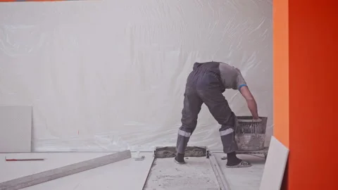 Builder places plaster on floor preparing for tile laying Stock Footage 146679824