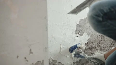 Builder plastering cement wall using metal trowel, spatula and white spackling Stock-Footage 150025375
