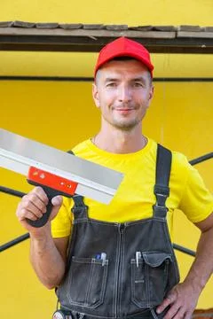 Builder portrait with putty knife, plastering repairs, home renovation busi.. Stock Photos