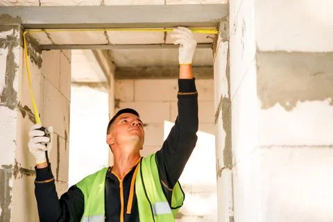 Builder positions ceiling segment, prepares for installation, teamwork coor.. Stock Photos