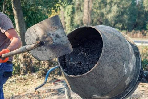 Builder preparing fresh concrete in a cement mixer Stock Photos