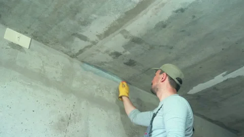 The builder primes the corner of the concrete wall with a special paint brush Stock Footage 197510710