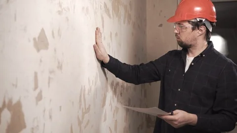 Builder in a protective glasses and a hat watching the flat. Stock Footage 86490529
