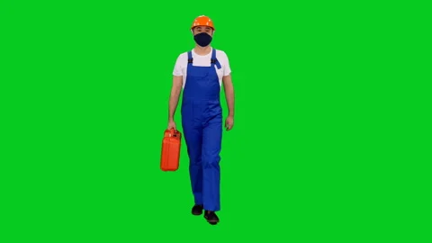 Builder in protective mask and hardhat walking with red case on green screen Stock Footage 131147194