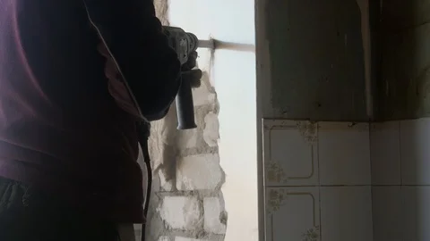 Builder punch removes old walls, removing the old plaster to the brick 動画素材 112582661