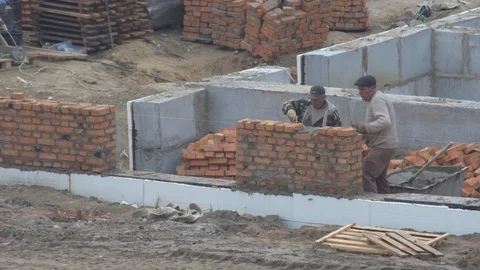 The builder puts a brick wall. the builder builds a brick wall.  build a house. Video stock 120673553