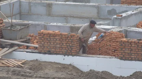 The builder puts a brick wall. the builder builds a brick wall. Stock-Footage 120674748